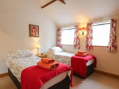 a bedroom with two beds with red blankets at The Golden Cross in Harleston