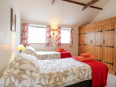 a bedroom with two beds and two windows at The Golden Cross in Harleston