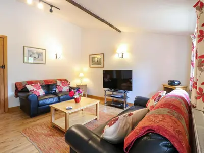 a living room with a couch and a tv at The Golden Cross in Harleston