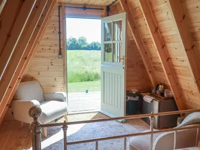 a room with a door in a log cabin at Oak Tree in Woodbridge
