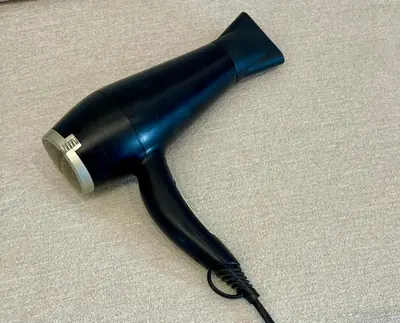 a black hair dryer sitting on a table at Boutique Cottage by Bishop's Stortford train station, easy to Stansted Airport & Parking in Bishops Stortford