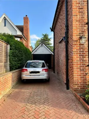 a car parked in front of a garage at Boutique Cottage by Bishop's Stortford train station, easy to Stansted Airport & Parking in Bishops Stortford