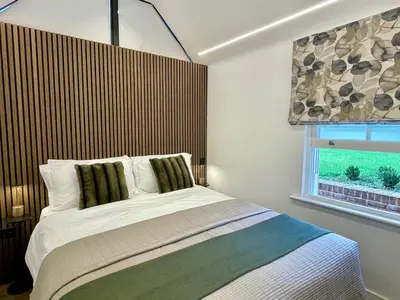a bedroom with a large bed and a window at Boutique Cottage by Bishop's Stortford train station, easy to Stansted Airport & Parking in Bishops Stortford