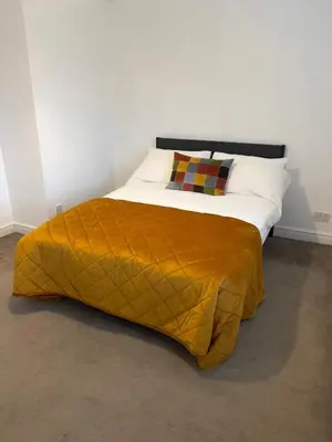 a bed with a yellow blanket on top of it at Long Stay Basildon Essex Business Contractors in Basildon