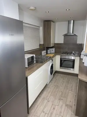 a kitchen with white cabinets and a stove top oven at Long Stay Basildon Essex Business Contractors in Basildon