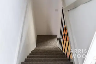 a stairway in a white building with stairs at Saltmarsh Cottage in Brightlingsea