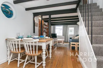 a dining room and living room with a table and chairs at Saltmarsh Cottage in Brightlingsea