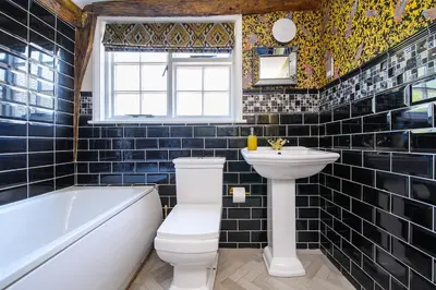 a bathroom with a toilet and a sink and a tub at Rock and Roll Suite In Manor House in Saffron Walden