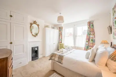 a white bedroom with a bed and a fireplace at 45 Carr Avenue, Leiston in Leiston