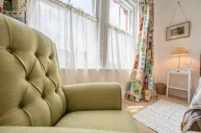 a living room with a chair and a window at 45 Carr Avenue, Leiston in Leiston