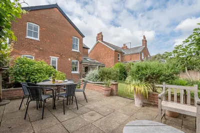 a patio with a table and chairs and a bench at 45 Carr Avenue, Leiston in Leiston