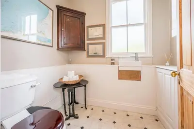 a bathroom with a toilet and a table and a window at 45 Carr Avenue, Leiston in Leiston