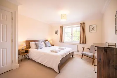a bedroom with a bed and a desk and a window at Cherry Tree House, Aldeburgh in Aldeburgh