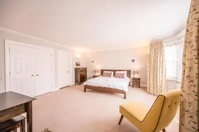 a bedroom with a bed and a chair at Cherry Tree House, Aldeburgh in Aldeburgh
