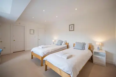 two beds in a room with white walls at Cherry Tree House, Aldeburgh in Aldeburgh