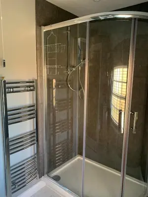 a shower with a glass door in a bathroom at The Coach House, Framsden