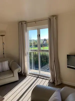 a living room with a large window and a couch at The Coach House, Framsden