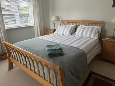 a bedroom with a bed with a green towel on it at Little Furrows, Wenhaston in Wenhaston