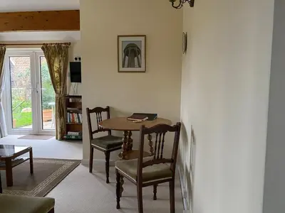 a living room with a table and chairs and a window at Little Furrows, Wenhaston in Wenhaston