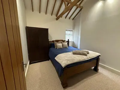a bedroom with a bed with blue sheets and pillows at Sleeps18 character barns in Old Hurst