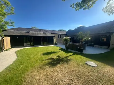 a yard with a frisbee in front of a house at Sleeps18 character barns in Old Hurst