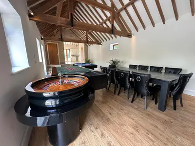 a room with a table and chairs and a game room at Sleeps18 character barns in Old Hurst
