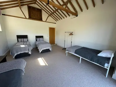 a bedroom with three beds in a room at Sleeps18 character barns in Old Hurst