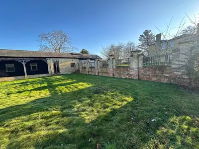 an empty yard in front of a brick building at Sleeps18 character barns in Old Hurst
