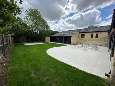 a patio with chairs and tables in a yard at Sleeps18 character barns in Old Hurst