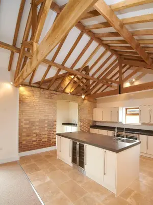 a kitchen with white cabinets and a black counter top at Sleeps18 character barns in Old Hurst