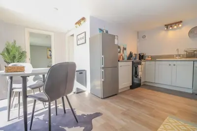 a kitchen with a table and a refrigerator at Gorgeous rural dog welcoming Milk Churn - Suffolk in Eye