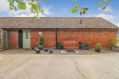 a brick house with a bench in front of it at Gorgeous rural dog welcoming Milk Churn - Suffolk in Eye