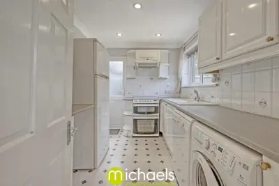 a white kitchen with a sink and a stove at For Contractors, businesses, families - next to Colchester Royal Grammar School in Lexden
