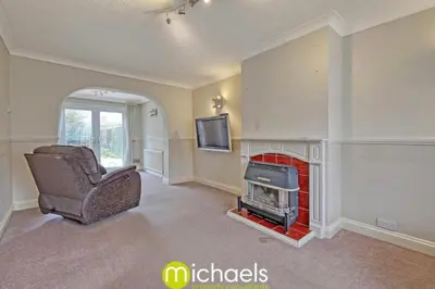 a living room with a chair and a fireplace at For Contractors, businesses, families - next to Colchester Royal Grammar School in Lexden