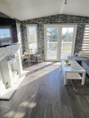 a living room with a couch and a table at Sunny corner caravan in Saint Osyth