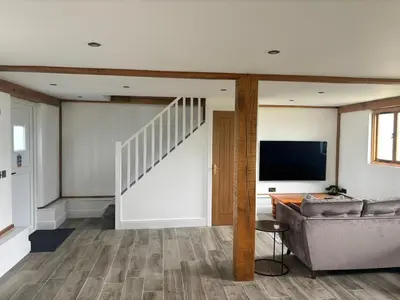 a living room with a couch and a flat screen tv at The Lodge in Newbourn