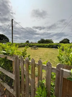 a wooden fence with a field in the background at The Lodge in Newbourn
