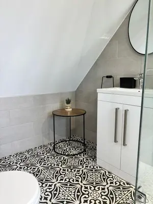 a bathroom with a toilet and a table on a tile floor at The Lodge in Newbourn