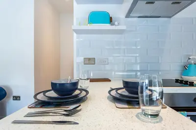 a kitchen with two bowls and glasses on a counter at Central Studio Flats with Parking in Southend on Sea in Southend-on-Sea