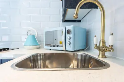 a kitchen sink with a blue toaster oven next to it at Central Studio Flats with Parking in Southend on Sea in Southend-on-Sea