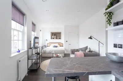 a white room with a bed and a table at Central Studio Flats with Parking in Southend on Sea in Southend-on-Sea