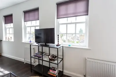 a living room with two windows and a flat screen tv at Central Studio Flats with Parking in Southend on Sea in Southend-on-Sea