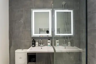 a bathroom with a sink and a mirror at Central Studio Flats with Parking in Southend on Sea in Southend-on-Sea