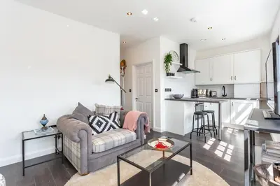 a living room with a couch and a kitchen at Central Studio Flats with Parking in Southend on Sea in Southend-on-Sea