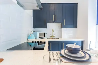 a kitchen with blue cabinets and a bowl on a counter at Central Studio Flats with Parking in Southend on Sea in Southend-on-Sea