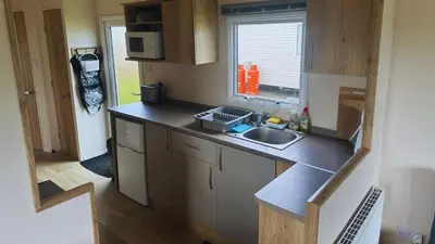 a small kitchen with a sink and a window at Sunny Beach Holidays Home in Jaywick Sands