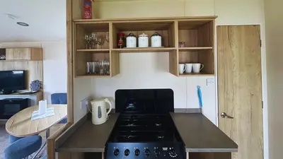 a kitchen with a stove and a counter top at Sunny Beach Holidays Home in Jaywick Sands