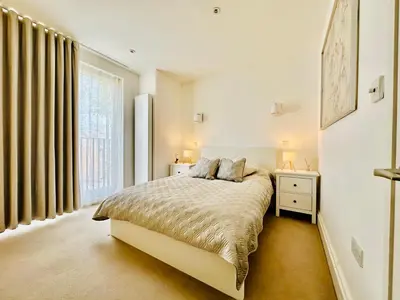 a white bedroom with a bed and a window at Business Not Operating Anymore in Cambridge