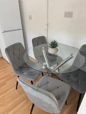 a glass table with two chairs and a plant on it at 3 bedrooms house in Stevenage