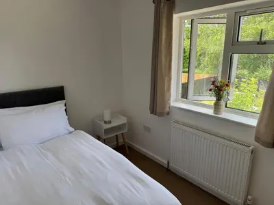 a bedroom with a white bed and a window at 3 bedrooms house in Stevenage